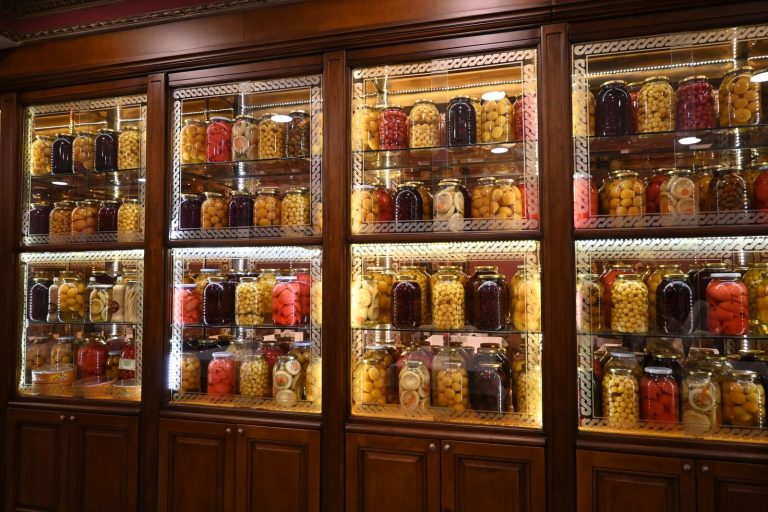 Wooden shelves stocked with jars of preserved fruits and vegetables