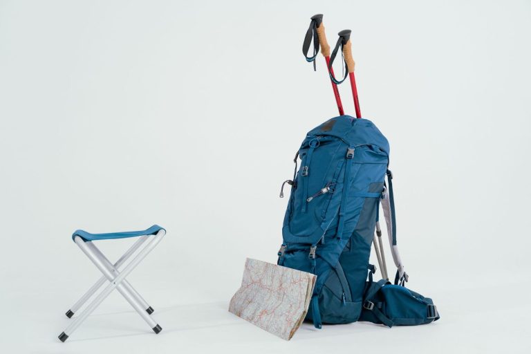 Packed backpack with map and trekking poles ready to go